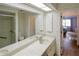 Bathroom featuring double sinks, a large mirror, and a walk-in shower at 860 Glen More Ct # B, Palm Harbor, FL 34684