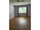 Light and airy bedroom with wood flooring, large window, and neutral paint at 860 Glen More Ct # B, Palm Harbor, FL 34684