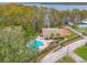Overhead view of the community pool and clubhouse surrounded by lush landscaping and lake views at 860 Glen More Ct # B, Palm Harbor, FL 34684