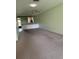 Spacious carpeted living room with neutral walls, ceiling fan, and built-in shelves into dining room at 860 Glen More Ct # B, Palm Harbor, FL 34684