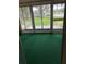 Empty screened porch with carpet and sliding glass door view of the green lawn outside at 860 Glen More Ct # B, Palm Harbor, FL 34684