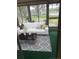 Inviting screened porch with comfortable seating, stylish rug, and a view of the neighborhood at 860 Glen More Ct # B, Palm Harbor, FL 34684