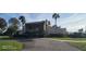 Community clubhouse set amongst mature trees, with a circular driveway and manicured landscaping at 90 S Highland Ave # 224, Tarpon Springs, FL 34689