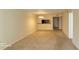 Spacious living room featuring neutral carpeting, lighting, and a pass-through to the kitchen at 90 S Highland Ave # 224, Tarpon Springs, FL 34689