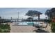 Relaxing community pool overlooking lake with lounge chairs, tables, umbrellas, and greenery at 90 S Highland Ave # 224, Tarpon Springs, FL 34689