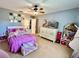 Charming bedroom featuring a bed, dollhouse, and decorative ceiling fan at 903 Setter Ct, Seffner, FL 33584