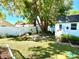 Landscaped backyard featuring a brick fire pit, wooden benches, decorative shed, and a privacy fence at 903 Setter Ct, Seffner, FL 33584