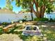 Backyard with a charming brick fire pit, wooden benches, mature trees, and a white privacy fence at 903 Setter Ct, Seffner, FL 33584