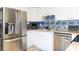 Kitchen with stainless steel refrigerator, appliances, white cabinets, and blue tile backsplash, perfect for a modern home at 903 Setter Ct, Seffner, FL 33584