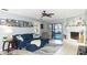 Bright living room featuring a ceiling fan, fireplace, sliding glass doors to pool area, and a comfortable blue sofa set at 903 Setter Ct, Seffner, FL 33584
