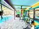 Colorful patio space featuring seating, dining area, ceiling fans, and access to the pool at 903 Setter Ct, Seffner, FL 33584