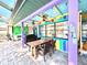 View of outdoor dining on colorful patio with ceiling fans and view of kitchen through window at 903 Setter Ct, Seffner, FL 33584