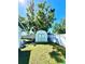 Backyard view featuring a shed with green trim and a large lawn, enclosed by a white fence at 903 Setter Ct, Seffner, FL 33584
