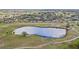 Elevated aerial view of pond and surrounding community; trails meander through park-like setting at 1015 Harefield Cir, Sun City Center, FL 33573