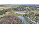 Beautiful aerial view of a serene pond surrounded by homes and lush foliage; a tranquil retreat at 1015 Harefield Cir, Sun City Center, FL 33573