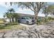 Charming single-story home featuring a well-manicured lawn and inviting curb appeal with driveway and shade tree at 1015 Harefield Cir, Sun City Center, FL 33573
