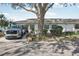 Cozy home with a well-kept lawn and landscaping, featuring a charming facade under a shade tree at 1015 Harefield Cir, Sun City Center, FL 33573