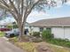 Charming single-story home with a well-manicured front yard and a mature tree providing shade at 1015 Harefield Cir, Sun City Center, FL 33573