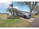 Attractive single-story home featuring a lush front yard with mature palms and ample driveway parking at 1015 Harefield Cir, Sun City Center, FL 33573