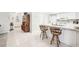 Bright eat-in kitchen featuring tile floors, white appliances and cabinets, and a breakfast bar with chairs at 1015 Harefield Cir, Sun City Center, FL 33573