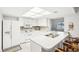 Bright white kitchen with updated appliances, light cabinets, tile backsplash, and an eat-in breakfast bar at 1015 Harefield Cir, Sun City Center, FL 33573