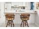 Bright kitchen featuring white cabinets, white appliances, breakfast bar, and a stainless steel sink at 1015 Harefield Cir, Sun City Center, FL 33573