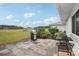 Tiled patio features a grill, chairs, and a table, perfect for outdoor entertaining with a large, grassy view at 1015 Harefield Cir, Sun City Center, FL 33573