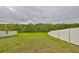 Lush backyard with a white fence, offering privacy and a view of the natural landscape at 10730 Shady Preserve Dr, Riverview, FL 33579