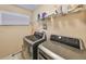 Well-equipped laundry room with modern appliances, a shelf, and a window at 10730 Shady Preserve Dr, Riverview, FL 33579