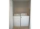 Laundry closet with wire shelving above the machines, white neutral walls, and carpeting at 10811 Brickside Ct, Riverview, FL 33579