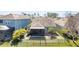 Aerial view of a fenced backyard with a screened in lanai and lush surroundings at 11421 Quiet Forest Dr, Tampa, FL 33635