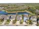 A serene aerial view of homes nestled by a tranquil pond, surrounded by lush greenery at 11421 Quiet Forest Dr, Tampa, FL 33635