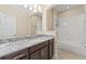 Bathroom featuring granite countertops, neutral tile, and combination tub and shower at 11421 Quiet Forest Dr, Tampa, FL 33635