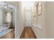 Hallway featuring hardwood floors and white trim, leading to adjacent rooms and front door at 11421 Quiet Forest Dr, Tampa, FL 33635
