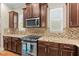 Modern kitchen with a stainless steel oven and dark cabinets with a tile backsplash at 11421 Quiet Forest Dr, Tampa, FL 33635