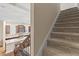 Carpeted staircase leads to an open-concept kitchen with granite countertops and dark wood cabinets at 11421 Quiet Forest Dr, Tampa, FL 33635