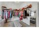 Spacious walk-in closet featuring organized shelves, hanging racks, a center ottoman, and soft carpet at 14247 Spanish Wells Dr, Hudson, FL 34667
