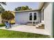 Backyard has a concrete patio, stairs leading to a set of French doors, and green grass at 14330 Channel Dr, Largo, FL 33774