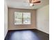 Bedroom features wood-look floors, a ceiling fan, neutral walls and a window with a backyard view at 14330 Channel Dr, Largo, FL 33774