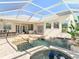 A backyard pool with a waterfall feature and an attached spa with a screened enclosure at 18111 Diamond Cove Ct, Tampa, FL 33647