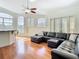 Bright living room with hardwood floors, large sectional sofa, and arched windows at 18111 Diamond Cove Ct, Tampa, FL 33647