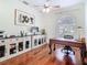 This office features hardwood floors, a ceiling fan, desk, and custom cabinets with glass doors at 18111 Diamond Cove Ct, Tampa, FL 33647