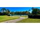 Tennis court with trees and shrubs around the outside, alongside a sidewalk to the entrance at 18111 Diamond Cove Ct, Tampa, FL 33647