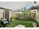 Landscaped backyard featuring artificial grass, a covered seating area, and privacy fencing at 1881 N Hercules Ave # 1205, Clearwater, FL 33765