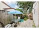 Backyard with a wooden deck featuring an outdoor table, chairs, umbrella, and lush greenery at 1881 N Hercules Ave # 1205, Clearwater, FL 33765
