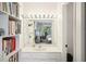 Bright bathroom with a large mirror, vanity lighting, and a glimpse into an adjacent bedroom or office space at 1881 N Hercules Ave # 1205, Clearwater, FL 33765