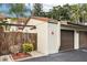 Exterior view of garages with brown doors and trim, set against a textured beige building at 1881 N Hercules Ave # 1205, Clearwater, FL 33765