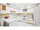 Well-lit kitchen featuring white cabinets, appliances, and tiled flooring at 1881 N Hercules Ave # 1205, Clearwater, FL 33765