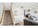 Open-concept living room featuring staircase, modern decor, and gray seating at 1881 N Hercules Ave # 1205, Clearwater, FL 33765