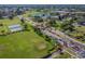 Aerial view featuring the community entrance, landscaping, and amenities like tennis courts and a pond at 2022 Heathfield Cir, Sun City Center, FL 33573